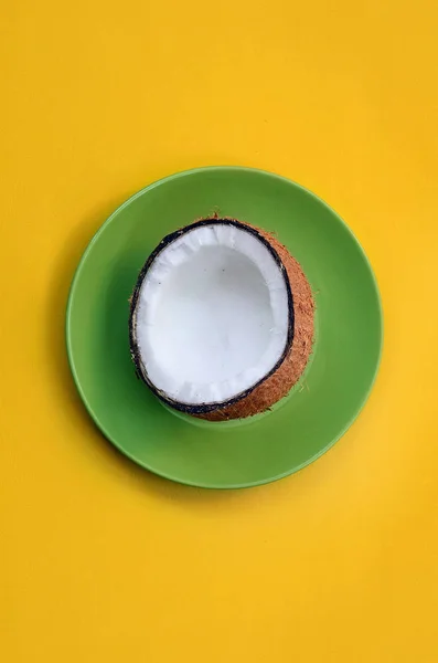 Sarı arka plan bir gölge döküm karşı yeşil bir plaka üzerinde açık Hindistan cevizi
