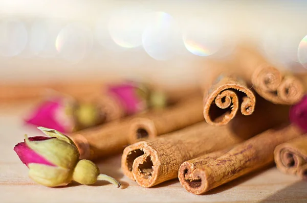 Cinnamon sticks and rose buds on a wood table