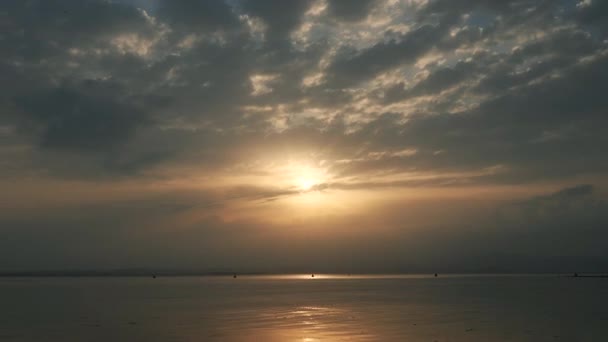 Zonsondergang aan het Gardameer in Italië, gouden zon achter bewegende wolken, 4k time lapse — Stockvideo