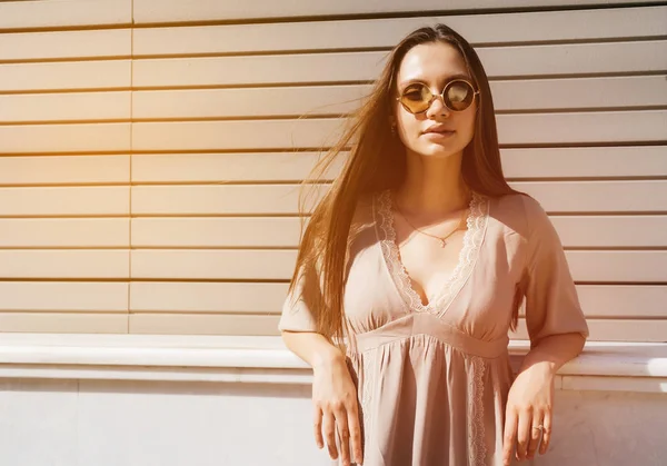 Jovem mulher da moda em óculos de sol posando ao ar livre sobre o bac de madeira — Fotografia de Stock