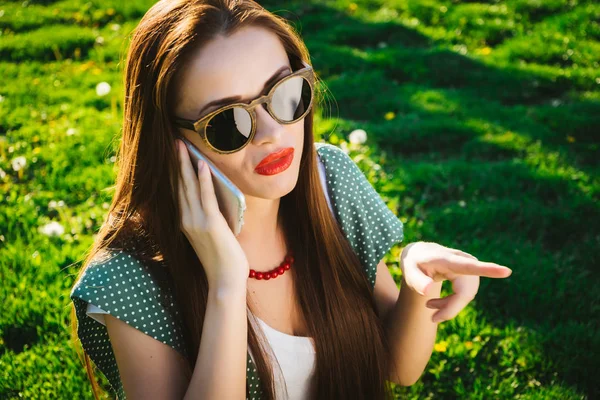 Donna con uno smartphone. Ragazza in occhiali da sole, estate — Foto Stock