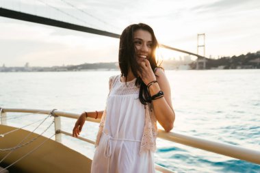 Gemideki kız gülümsüyor. Sağa doğru görünüyor