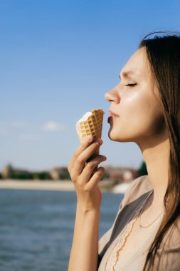 Bir kız zevk ile dondurma yiyor