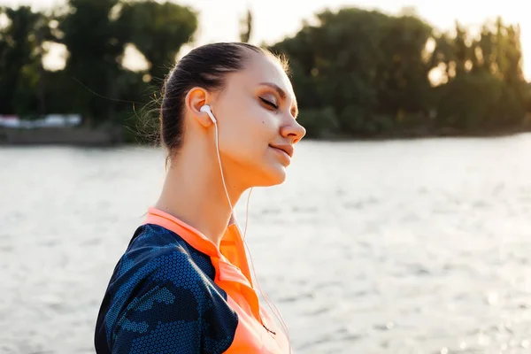 Aktiv flicka lyssnar på musik i hörlurar — Stockfoto