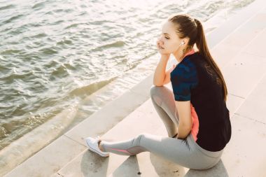 Sportif bir kız, bir yerde nehir kıyısında görünüyor