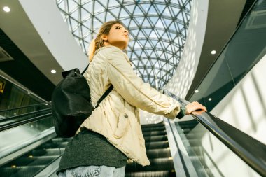 Güzel bir kız bir yürüyen merdiven tırmanma