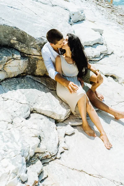 Aşık bir çifti taşlar ve öpücük üzerinde oturur