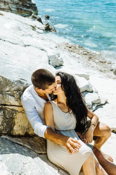 Пара влюбленных целует камни у воды — стоковое фото