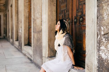 Kilisenin kapısını genç bir kadın oturur