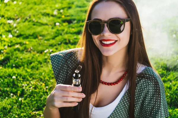 Felice moda sorridente Donna in occhiali da sole fumo vaporizzatore sulla strada, fumo — Foto Stock