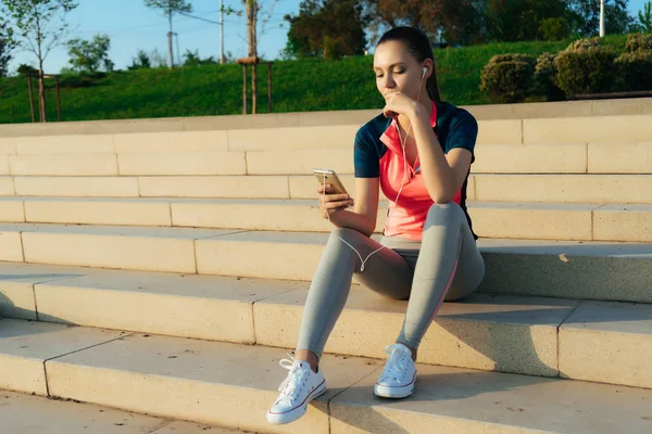 Sports girl rests on the steps