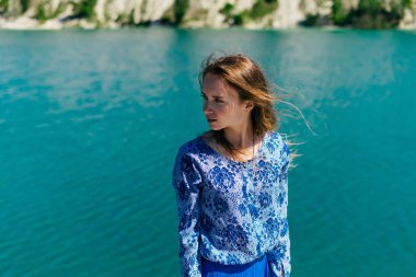 Genç sevimli kız göl kıyısında duruyor