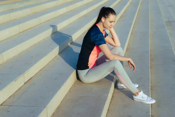 Спортивна дівчина відпочиває на сходах після бігу — стокове фото