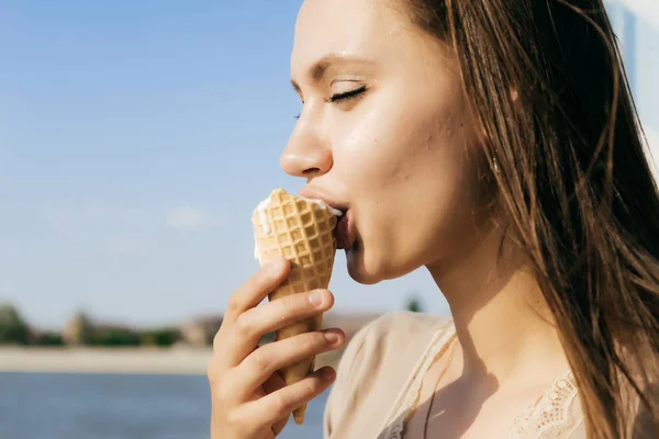 Молодая женщина с удовольствием ест мороженое — стоковое фото