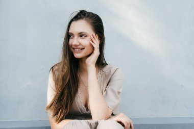 Genç güzel kız gülümseyerek oturur