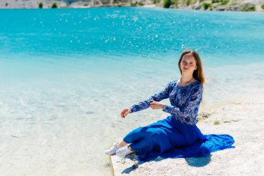 Genç bir kız göl üzerinde oturuyor