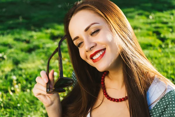 Gülümseyen kadın güneş gözlüğü, boşaltmak tutar. Gözlük ile