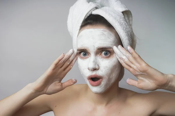 Mujer con cosméticos blancos mack en la cara, exfoliante, hidratante — Foto de Stock