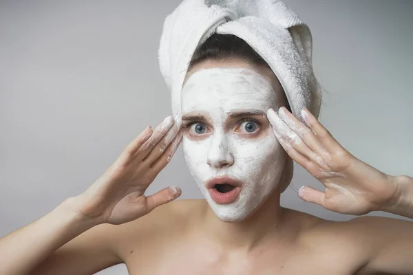 Mujer con cosméticos blancos mack en la cara, exfoliante, hidratante —  Fotos de Stock