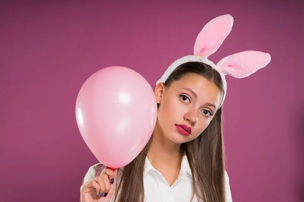 Genç bir kız tavşan kulaklı bir hava ile şişirilen topu tutuyor — Stok fotoğraf