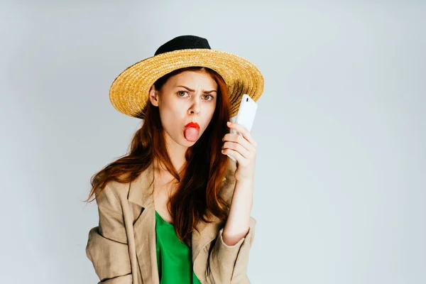 帽子の美しい少女が舌を示しています — ストック写真
