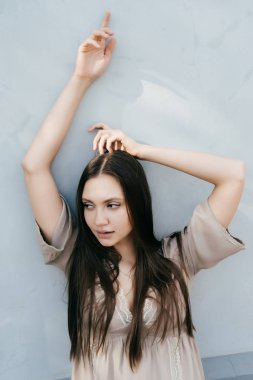 Bej renkli elbiseli bir genç rahat kadın bir kenara görünüyor