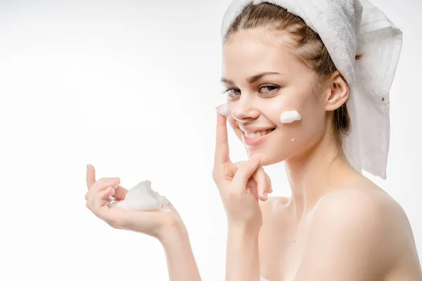 Close-up of beautiful young woman applying cream with bath towel on head covering her breasts,closed eyes,enjoying. — Stock Photo, Image