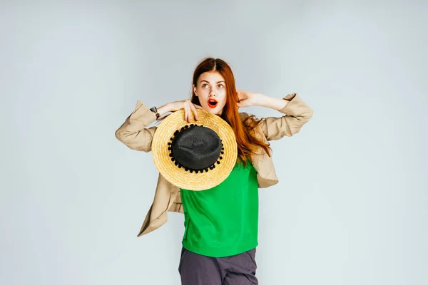 Verbaasd jong meisje in een groene trui en een stro hoed, de koper voordat winkelen — Stockfoto