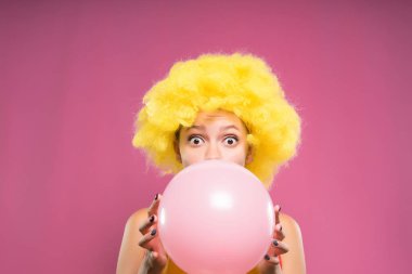 Bir sürpriz kız palyaço peruk içinde onun doğum günü için bir top açılırsa. Pembe sakız balonu
