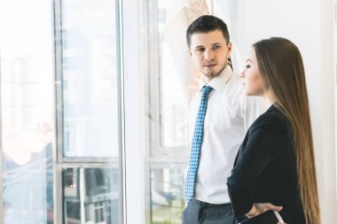 Bir çift bir pencere yakınında bir proje ayakta tartışırken iş işçilerin