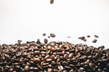 Kavrulmuş kahve çekirdekleri beyaz düşen izole