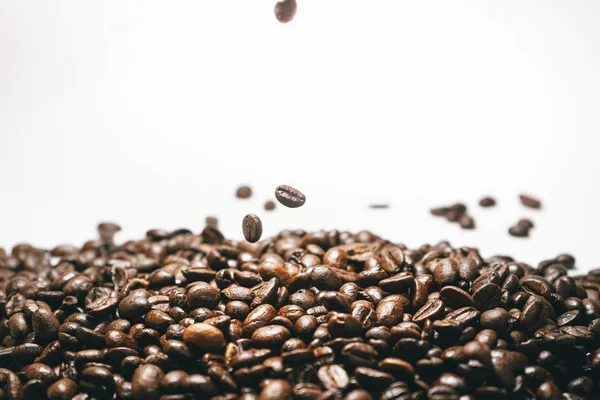 Kavrulmuş kahve çekirdekleri beyaz düşen izole