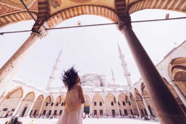 Caminin mavi arka plan üzerinde başörtüsü duran genç kadın gezgin. Yaz tatillerinde seyahat