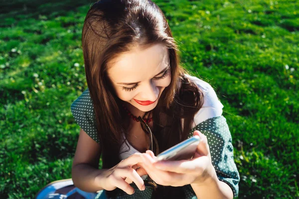 Mujer de mensajes de texto, sorprendido, smiling.grass fondo de verano — Foto de Stock