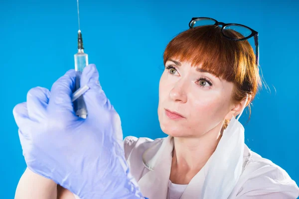 Женщина-врач собирает жидкость в концентрированном шприце — стоковое фото