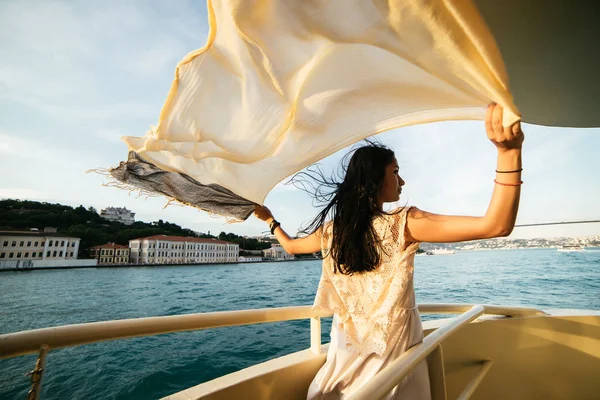 Bir kız bir tekne, bir teknede günbatımı şehir manzarasına bakar