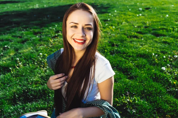 Mulher sorridente bonito sentado na grama no dia de verão — Fotografia de Stock