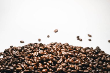 beyaz zemin üzerine düşen aromatik kavrulmuş kahve çekirdekleri yakın çekim