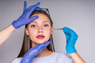 Kendini beyaz bir arka plan üzerinde bir enjeksiyon yapma uzun eldiven ile şirin kız