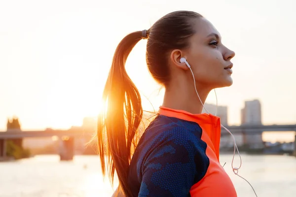 cute girl jogging staring into the distance at sunset