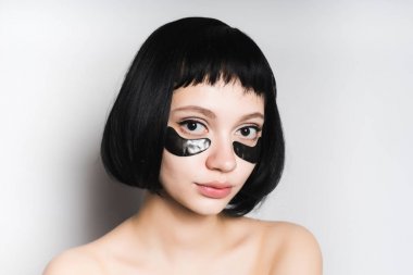 kısa siyah saçlı sevimli kız kameraya, spa yordamı görünüyor