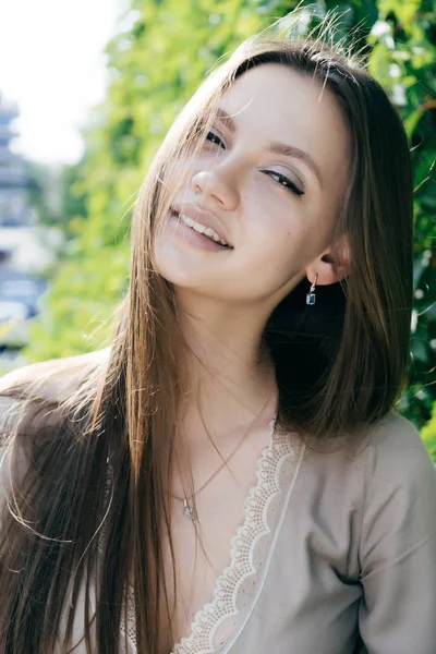 Civettuola ragazza carina con i capelli lunghi guarda la fotocamera per strada — Foto Stock