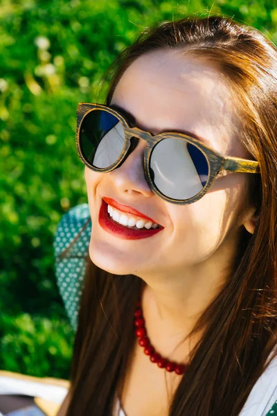 Cara de mujer de cerca en gafas de sol, gafas de madera, sonrisa blanca — Foto de Stock