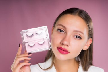 Yapay sahte kirpik ile bir kutu tutan genç güzel kadın