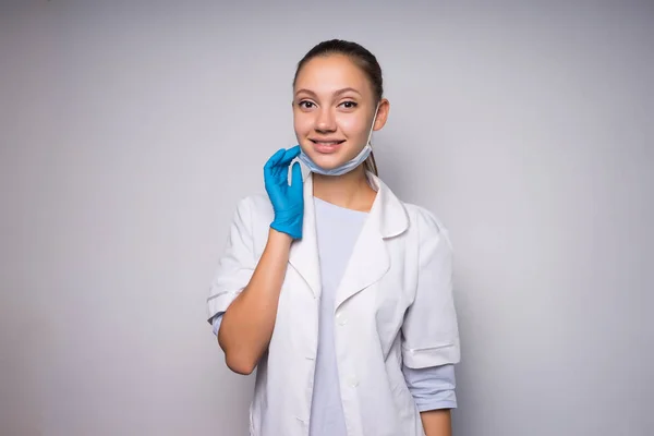 Chica en la práctica, un médico en la práctica sonriendo, con una máscara — Foto de Stock