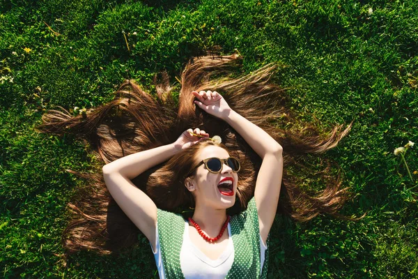 Helthy vlasy, zuby, úsměv mladá dívka na trávu, zobrazit výše, lesk žena — Stock fotografie
