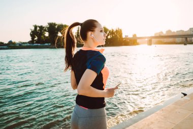 Şehirde bir Nehri yakınında bir motive runner kadın çalışır