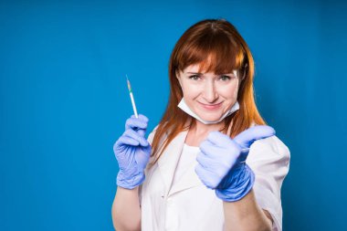 Kadın doktor bir şırınga elinde tutuyor ve bir sınıf jest, bir başparmak çıkar ortaya