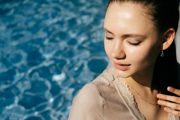 Donna affascinante vicino alla piscina a riposo, chiuse gli occhi. Vacanza. — Foto Stock