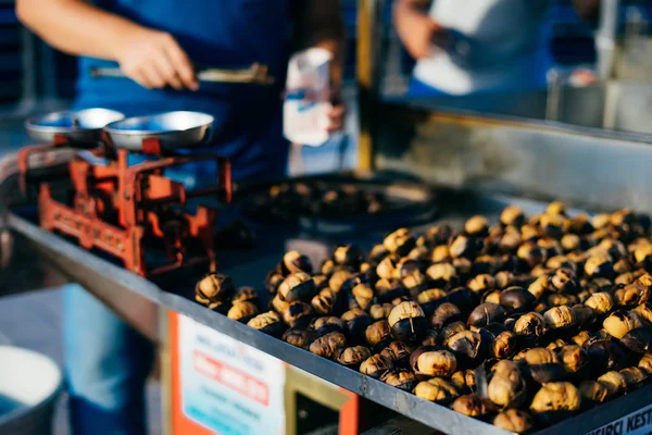 Homem frito castanhas na rua de perto — Fotografia de Stock